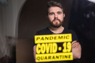 Portrait of young man standing at home