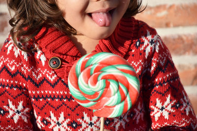 Midsection of boy holding lollipop