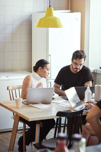 Woman and man using laptops