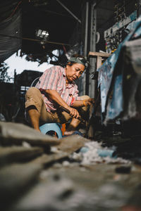 Senior woman working on wooden equipment