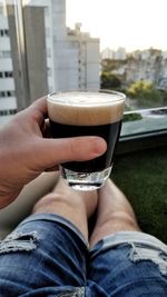 Midsection of woman drinking beer in glass