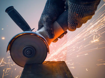 Cropped hand of man welding metal