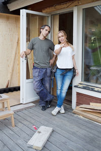 Full length of woman showing something to man at construction site