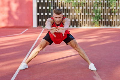 Full length of young woman exercising on court