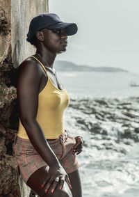 Africa woman with blue cap by the sea cape coast ghana west africa.