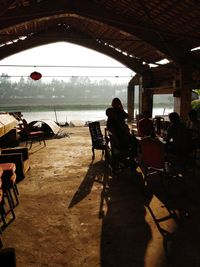 People sitting on chair at railroad station