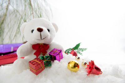 Teddy bear and christmas presents on fake snow