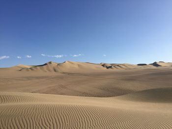 Scenic view of desert against blue sky