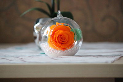 Close-up of orange rose on table