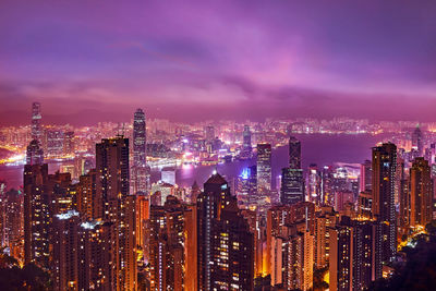 Illuminated cityscape against sky at night