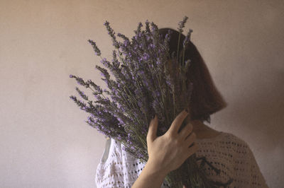 Close-up of hand holding purple flower