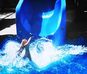 Woman jumping in swimming pool