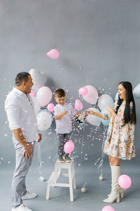 Gender reveal party. stylish beautiful family with a baby pop a balloon to find out the gender 