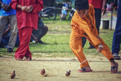 Boy spinning top on field