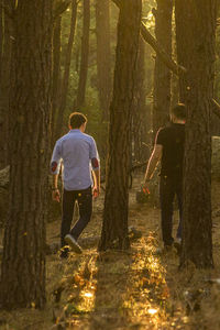 Rear view of people walking in forest