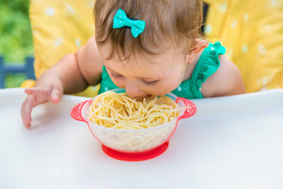 Cute girl eating spaghetti outdoors