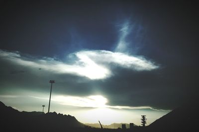 Low angle view of sun shining through clouds