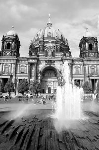 Water fountain against buildings in city