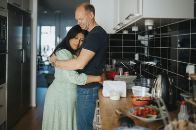 Loving couple hugging in kitchen