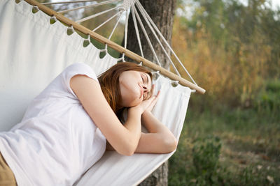 Full length of woman relaxing on hammock