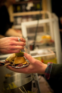 Close-up of hands holding burger