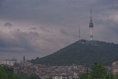 Buildings in city against cloudy sky