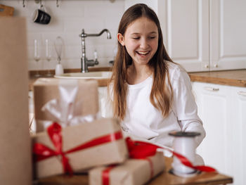 Portrait of young woman using mobile phone while sitting at home