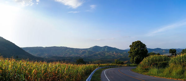 Road leading towards mountains against sky