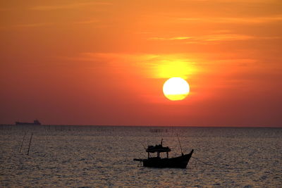 Silhouette boat in sea against sky during sunset