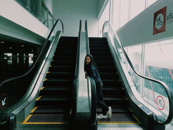 Low angle view of woman on escalator