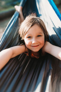 Portrait of happy girl lying in hammock