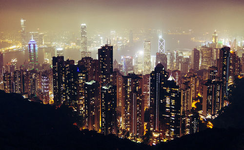 Illuminated cityscape against sky at night