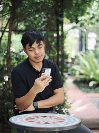 Young man using mobile phone on table