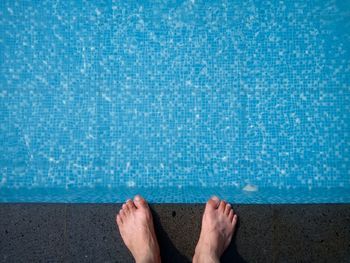 Low section of person standing on poolside