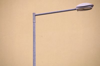Close-up of street lamp against wall