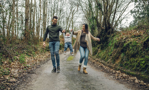 People on road amidst trees in forest