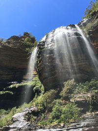 Low angle view of waterfall against sky