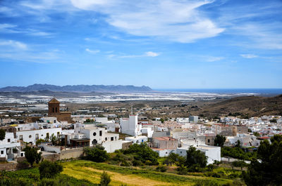 High angle view of townscape by sea against sky