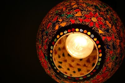 Close-up of illuminated tea light candle against black background