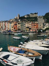 Boats moored at harbor against buildings in city