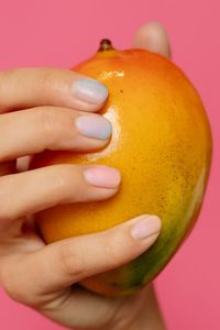 Close-up of hand holding orange slice