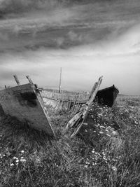 Windmills on landscape against cloudy sky