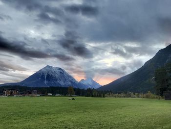 Scenic view of field and mountains against sky
