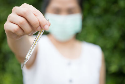 Midsection of woman holding plant