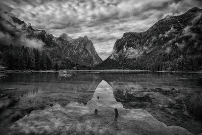 Scenic view of lake and mountains against cloudy sky