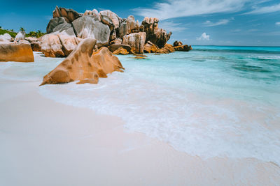 Rock formation on beach against sky