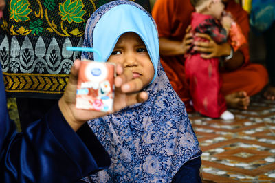 Portrait of a smiling girl holding camera