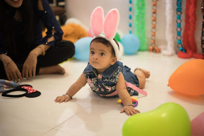 Cute boy sitting on floor at home