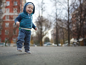 Smiling baby boy walking on street