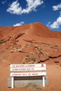 Information sign in desert against sky